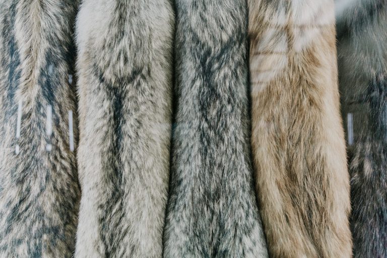 a bunch of fur coats hanging on a rack